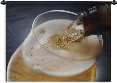 Wandkleed Bier - Bier dat tegen een donkere achtergrond wordt gegoten Wandkleed katoen 120x90 cm - Wandtapijt met foto