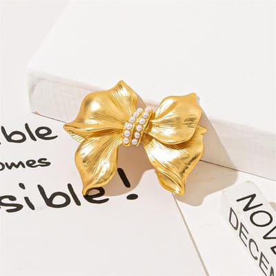 Parelstrik corsage dames, luxe en verfijnde broche, stijlvolle accessoire voor bij een pak of trui. beige