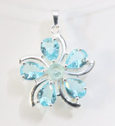 Bloemvormige zilveren hanger met blauwe topaas