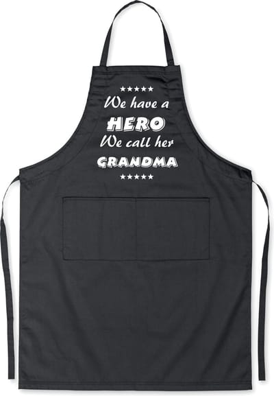 Mijncadeautje Schort - We have a hero, GRANDMA - opdruk wit - mooie en exclusieve keukenschort - zwart