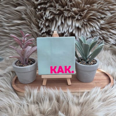 Robuust Wenstegeltje “KAK.” – 10X10CM – Humoristisch Cadeau – Trendy nu – Cadeau voor Nieuwe Woning, Housewarming of voor vriend(in) – Sfeervol en Persoonlijk – Zomaar - Wc decoratie – Decoratief Tegeltje met Standaard – Cadeau Idee