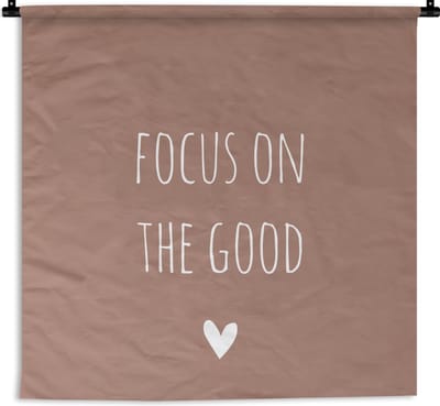 Wandkleed - Wanddoek - Engelse quote "Focus on the good" met een hartje tegen een bruine achtergrond - 90x90 cm - Wandtapijt