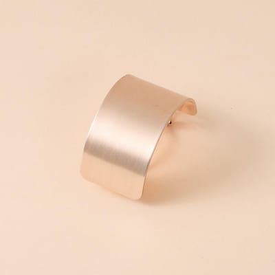 Een Haarklem Met Een Eenvoudige Stijl En Een Gouden Textuur, Met Een Glanzend Geborsteld Effect En Een Paardenstaartklem Ontwerp.