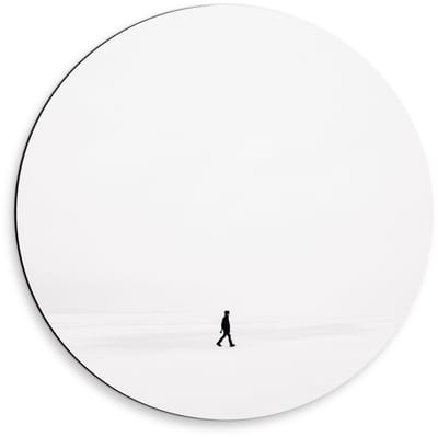 Dibond Wandcirkel - Persoon aan het Lopen in de Sneeuw - 50x50cm Foto op Aluminium Wandcirkel (met ophangsysteem)