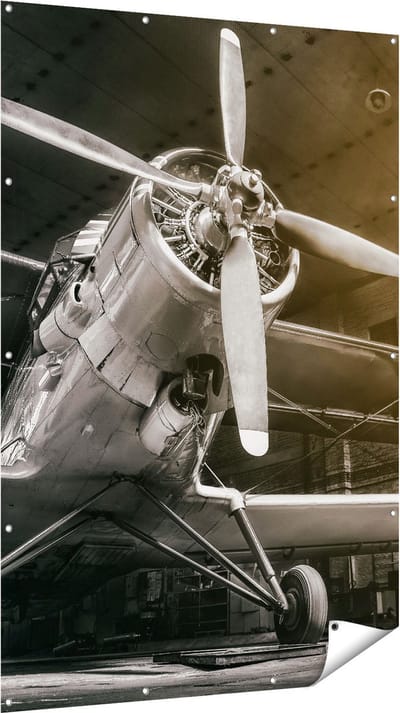Gards Tuinposter Oud Vliegtuig in een Hangar - Zwart Wit - 120x180 cm - Tuindoek - Tuindecoratie - Wanddecoratie buiten - Tuinschilderij