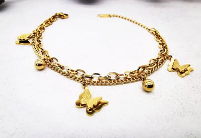 Twee stijlen - één armband - Double Chains - vlinder - bedeltjes - combineert een verfijnde en grove schakelketting voor een moderne, gelaagde look. Gemaakt van goudkleurig RVS – stijlvol, sterk en waterproof.