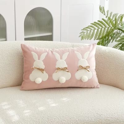 Roze Velvet Decoratiekussen met 3 Konijnen – Luxe Sierkussen met Strikjes & Pompon Staartjes – 30x50 cm – Kinderkamer / Paasdecoratie / Woonaccessoires