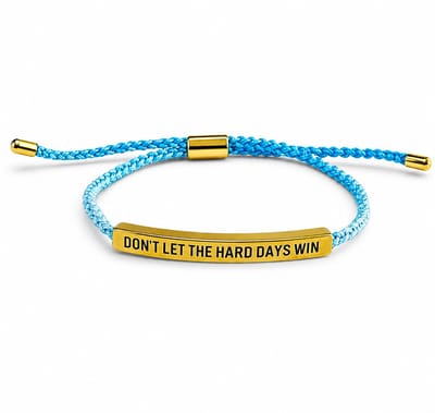 Lichtblauw gevlochten koord armband voor heren en dames met goudkleurige plaat en gegraveerde tekst "Don't Let The Hard Days Win" – verstelbaar