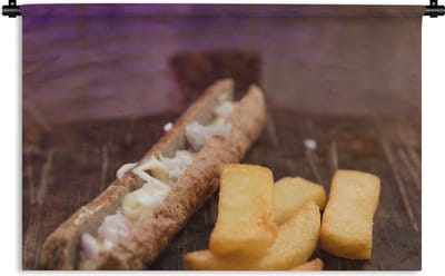 Wandkleed Frikandel - Een frikandel met kleine patat op een houten snijplank Wandkleed katoen 120x80 cm - Wandtapijt met foto