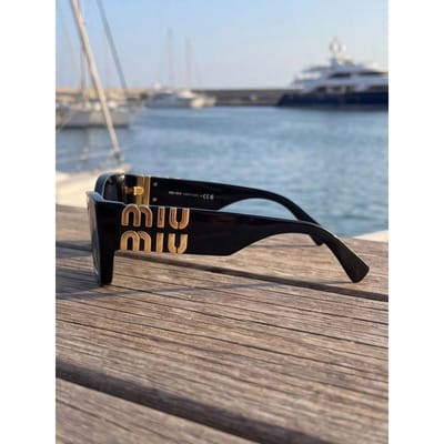 Miu Miu SMU09W Zonnebril - Zwarte Cat-Eye Monturen met Gouden Logo zwart