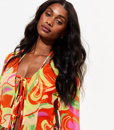 Strandshirt van chiffon met gekleurde krullen en strik aan de voorkant
