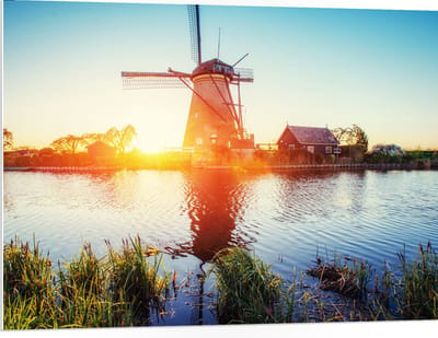 WallClassics - PVC Schuimplaat - Zonlicht langs Hollandse Molen aan het Water - 100x75 cm Foto op PVC Schuimplaat (Met Ophangsysteem)