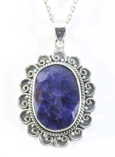 Grote bewerkte zilveren hanger met blauwe saffier aan ketting