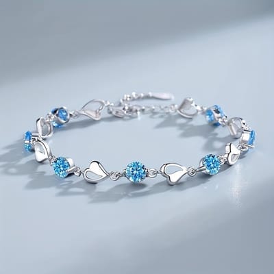 Sjika - Zilverkleurige armband met blauwe kristallen & hartjes – Luxe damesarmband – Elegant & romantisch design – Perfect cadeau voor haar