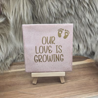 Robuust Wenstegeltje “Our Love is Growing” – 10x10 cm – Zwangerschap & Liefde Wanddecoratie - Our Love is Growing tegel – zwangerschap aankondiging – babyshower cadeau tegel – tegeltje baby op komst – Decoratief Tegeltje met Standaard – Cadeau Idee