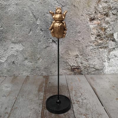 Gouden insect op standaard