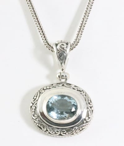 Traditionele bewerkte zilveren hanger met blauwe topaas aan ketting