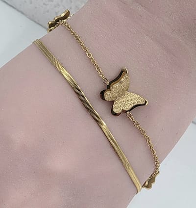 Twee stijlen - één armband - Double Chains - vlinder - bedeltjes - combineert een verfijnde schakelketting voor een moderne, gelaagde look. Gemaakt van goudkleurig RVS – stijlvol, sterk en waterproof.
