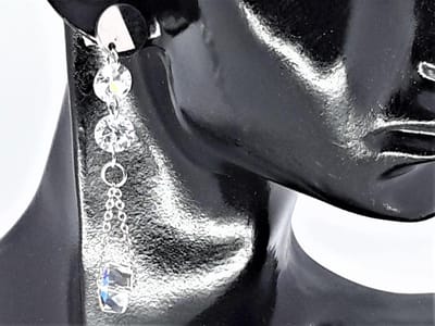 Oorhanger chirurgisch staal zilverkleurig met twee kristal op ketting en eronder een rond AB crystal die alle kleur schitterend.