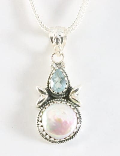 Bewerkte zilveren hanger met wilde parel en blauwe topaas aan ketting