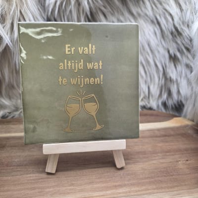 Robuust wenstegeltje "Er valt altijd wat te wijnen!" – Cadeau - Hip trendy tegeltje – Tegeltje met Spreuk – Keramiek – 10x10 cm – Wanddecoratie – Sfeervol en Persoonlijk – Trendy nu – Origineel cadeau - Incl standaard