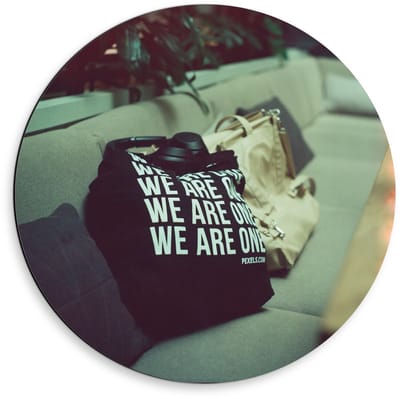 Dibond Wandcirkel - Bank met Tassen en Tekst We Are One - 50x50cm Foto op Aluminium Wandcirkel (met ophangsysteem)