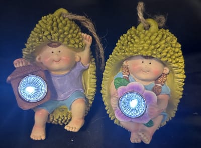 Polyresin solarlamp "hangende kids in Tropische vrucht" - Set van 2 stuks - met lantaarn LED - jongen met lantaarn en meisje met bloem - Hangend & Staand model - hoogte 12 x 9 x 8 cm - Met ophangkoord - Tuindecoratie - Tuinverlichting