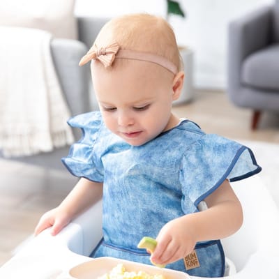 Bumkins Ruffle Apron Bib - Waterdichte Schortslab met Ruches - Knoeislab en Slabbetje voor Baby en Peuter - Machinewasbaar - BPA- en PVC-vrij - Crushed Denim - Jeansblauw - 6-24 maanden