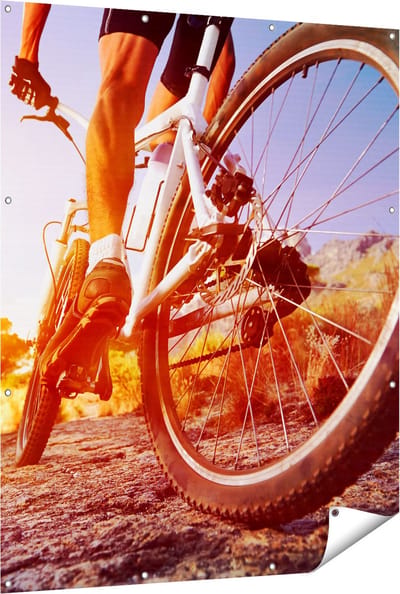 Gards Tuinposter Mountainbike Fietser op Stenen bij Zonsopgang - 120x150 cm - Tuindoek - Tuindecoratie - Wanddecoratie buiten - Tuinschilderij
