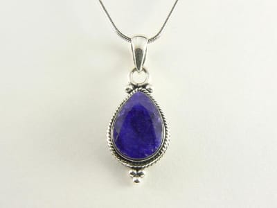 Bewerkte zilveren hanger met blauwe saffier aan ketting