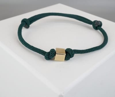 Donker groene armband met gouden kubus
