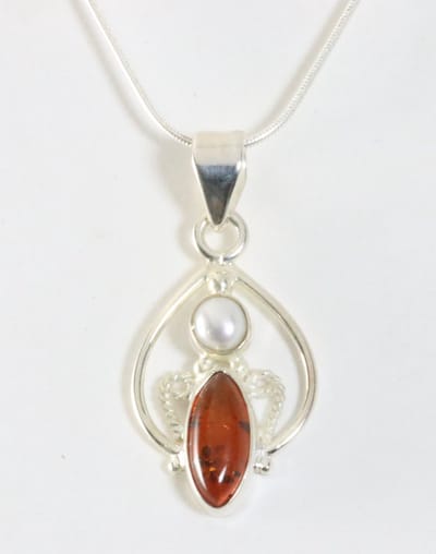 Fijne opengewerkte zilveren hanger met amber en zoetwater parel aan ketting