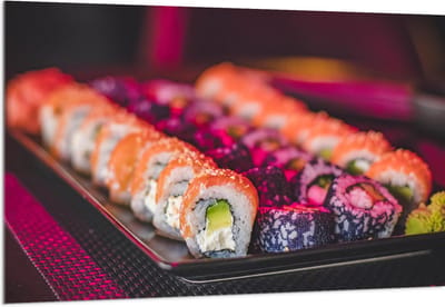 Acrylglas - Schaal Vol met Verschillende Smaken Sushi in Paars Licht - 150x100 cm Foto op Acrylglas (Met Ophangsysteem)