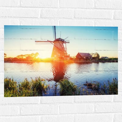 WallClassics - Muursticker - Zonlicht langs Hollandse Molen aan het Water - 75x50 cm Foto op Muursticker
