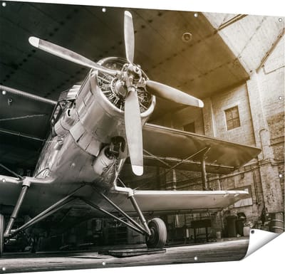 Gards Tuinposter Oud Vliegtuig in een Hangar - Zwart Wit - 150x120 cm - Tuindoek - Tuindecoratie - Wanddecoratie buiten - Tuinschilderij