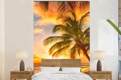 Behang - Fotobehang Zonsondergang - Palmboom - Wolken - Zee - Strand - Breedte 195 cm x hoogte 300 cm