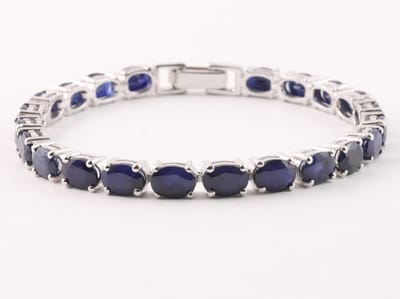 Zilveren tennisarmband met blauwe saffier - lengte 17 cm.