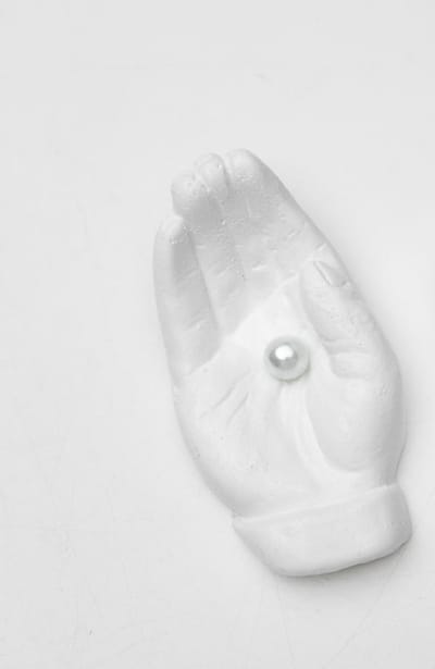 Beeld hand met parel wit