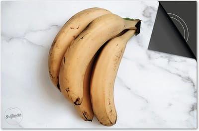 Inductie beschermer 60x60 - afdekplaat inductie mat - Dietrix Kookplaat beschermer - Exclusief - Groente en Fruit - Bananen tros op marmer wit