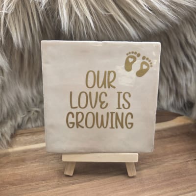 Robuust Wenstegeltje “Our Love is Growing” – 10x10 cm – Zwangerschap & Liefde Wanddecoratie - Our Love is Growing tegel – zwangerschap aankondiging – babyshower cadeau tegel – tegeltje baby op komst – Decoratief Tegeltje met Standaard – Cadeau Idee