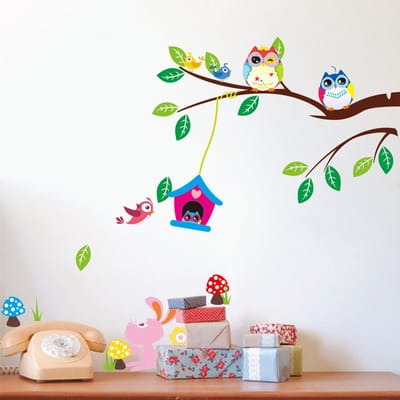 Decoratieve muurstickers met uilen en een vogelkooi in een boom.