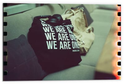 Dibond - Bank met Tassen en Tekst We Are One - 60x40cm Foto op Aluminium (Wanddecoratie van metaal)