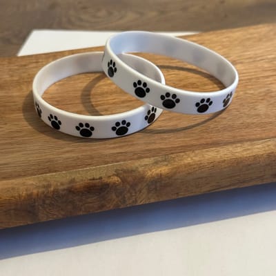 GoedeDoelen.Shop | Polsbandje Black Paws | Silicone Polsbandje | Paw | Pootafdruk | Unisex | Vriendschapsarmband | Statement Armband | Dierenliefde | Hondenarmband | Kattenarmband | Samen voor Dieren | Dierenvriend | Wellness-House
