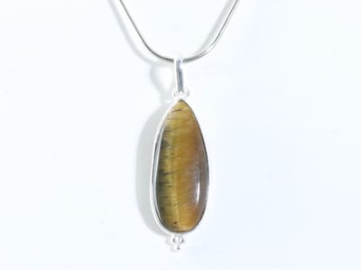 Lange druppelvormige zilveren hanger met tijgeroog aan ketting