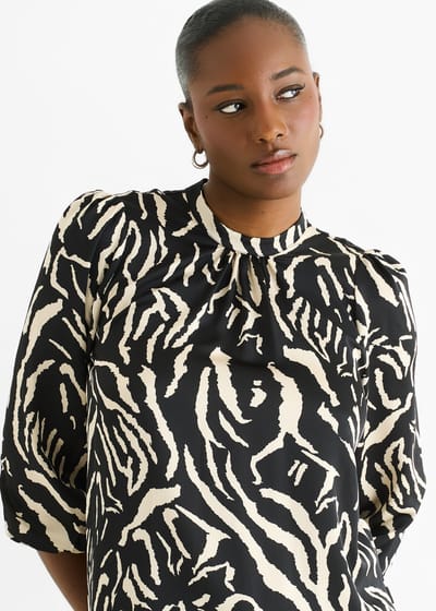 Zwarte satijnen blouse met hoge kraag en dierenprint