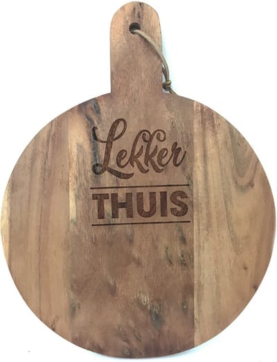 Ronde snijplank/borrelplank tekst gravure , quote: LEKKER THUIS. Het formaat is 40x30cm incl. handvat en 30cm doorsnede excl. handvat.