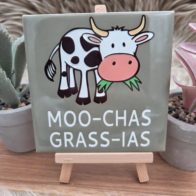 Wenstegeltje "Moo-chas Grass-ias” – Grappige Koe Tegel - Hip trendy tegeltje – Wanddecoratie – Cadeau voor Nieuwe Woning, Housewarming of Gezinscadeau – Sfeervol en Persoonlijk – Trendy nu – Decoratief Tegeltje met Standaard – Cadeau Idee