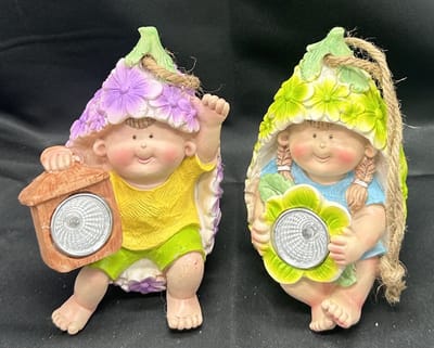 Polyresin solarlamp "hangende kids in bloem" - Set van 2 stuks - met lantaarn LED - jongen en meisje - paarse bloem + groene bloem - Hangend & Staand model - hoogte 12 x 9 x 8 cm - Met ophangkoord - Tuindecoratie - Tuinverlichting