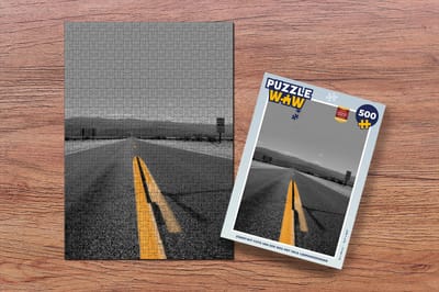 Puzzel Zwart-wit foto van een weg met gele lijnmarkeringen - Legpuzzel - Puzzel 500 stukjes