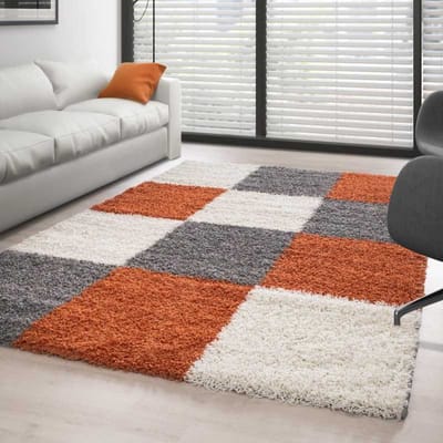 Hoogpolig vloerkleed met een terracotta-wit-grijs geblokt patroon. 80x150 cm